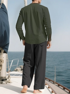 Men's linen set featuring olive green shirt and black pants on a boat deck