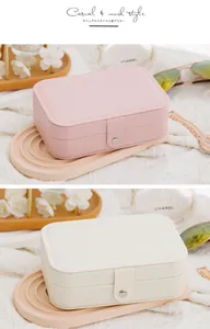 Detailed view of pink and beige PU leather travel jewelry boxes with snap closures