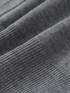 Close-up of grey knit cardigan showing detailed ribbed cuffs and soft fabric texture