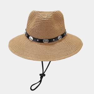 Detail of beige straw Panama hat with black leather band and silver vintage buckles