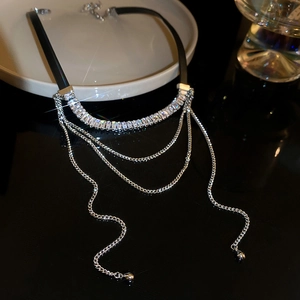 Macro shot of silver collar necklace with rectangular crystals and draped fringe chains