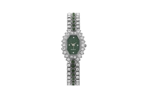 Detailed macro view of a silver watch band set with green stones and sparkling quartz dial