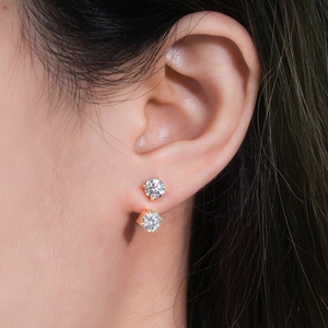 Close-up of elegant double-stud moissanite earrings in gold finish worn by a model