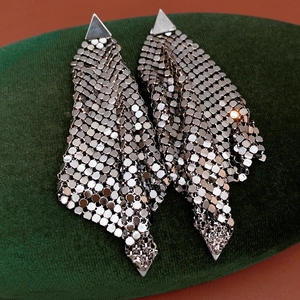 Detail of silver triangular tassel earrings showing the flexible metallic fabric texture