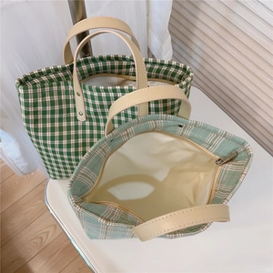 Close-up of checkered tote bag interior with zipper pocket and leather handles
