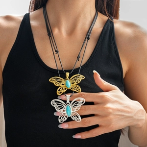 Detailed close-up of hollow butterfly pendant featuring turquoise stone and wax rope cord