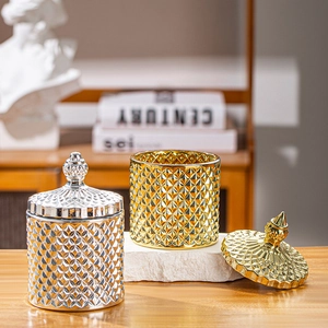 Detail of gold and silver glass storage jars with geometric diamond relief patterns and lids