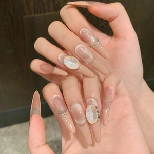Elegante lange spitze nudefarbene Katzenaugen-Klebenägel mit großen Oval-Strasssteinen