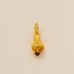 Gold flower necklace pendant with small red zircon stone on clean beige background
