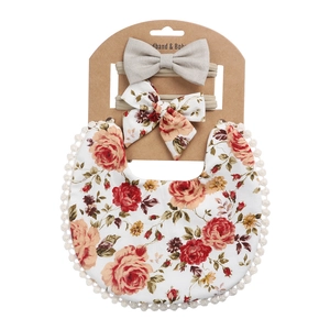 Baby-Lätzchen aus Baumwolle mit Blumenmuster und Stirnband auf Kraftkarton mit Spitze