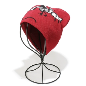 Detail of red knit beanie featuring black and white jacquard dragon pattern and fine texture