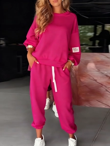 Detail of rose pink knitted tracksuit featuring crewneck top and matching joggers