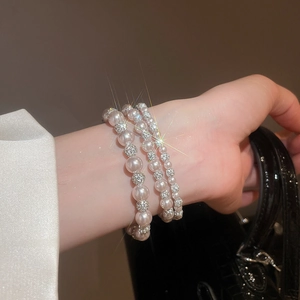 Macro shot of elegant multi-layer pearl bracelet with sparkling rhinestone beads and star flare