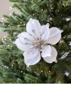 Detail of white velvet magnolia Christmas tree flower with gold glitter and crystal core