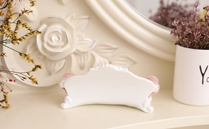 Detailed close-up of a vintage mini sofa jewelry display stand with pink velvet finish