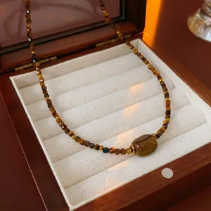 Tiger eye stone beaded necklace with a central barrel bead in a dark wood jewelry box