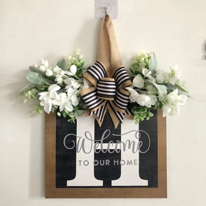 Detail of wooden door sign with letter H and decorative floral black white bow