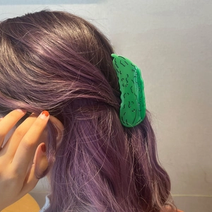 Funny green cucumber acetate hair claw clip shown on purple hair for a stylish look