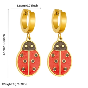 Detail of red enamel ladybug earrings in gold finish with 3.5cm length dimensions