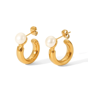 Detail view of gold C-shaped stainless steel earrings featuring round white pearls