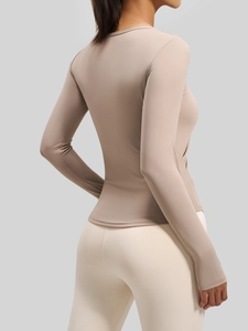 Top da yoga a maniche lunghe con scollo a V e leggings in tonalità terra e crema