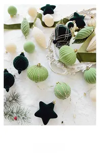 Velvet Christmas ornaments in various shapes with gold glitter on snowy background