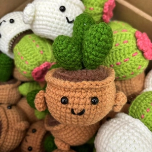 Close-up of handmade crochet succulent dolls with cute faces and soft yarn texture