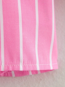 Détail macro de l'ourlet en coton à rayures roses et blanches et couture précise