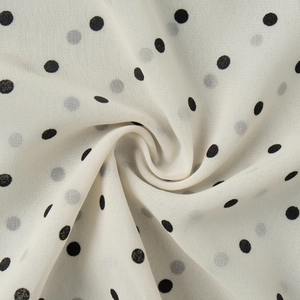 Detailed close-up of lightweight polka dot chiffon fabric with elegant draped texture