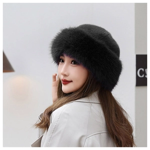 Detail of warm black faux fur trim on a winter beanie hat worn with a white coat