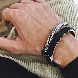 Detail of vintage silver twisted bangle with 'always in' engraving and black cuff bracelet