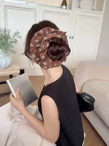 French vintage brown polka dot chiffon scrunchie shown on a low bun hairstyle