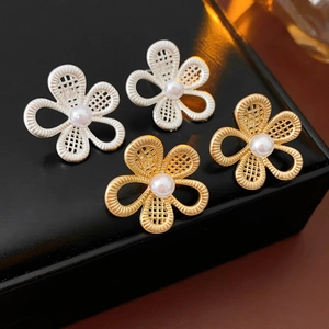 Vue détaillée des boucles d'oreilles fleur ajourées avec perles sur un écrin