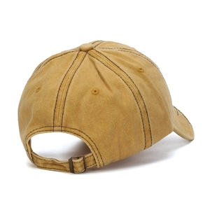 Detail view of mustard yellow baseball cap featuring adjustable bronze metal buckle