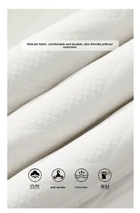 Detailansicht von weißem Baumwollvlies mit Rauten-Jacquard-Muster und weicher Faserstruktur