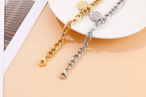 Detailed shot of gold and silver chain bracelets with Tree of Life coin charms