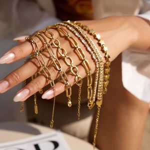 Vue détaillée de bracelets superposés en acier inoxydable doré 18 carats avec étoiles