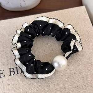 Macro detail of retro polka dot hair scrunchie with elegant faux pearl and lace trim