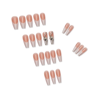 Detailed flat lay of nude French press-on nails with rhinestone bow and silver accents