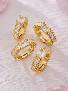 Macro detail of gold plated rings with micro-set rectangular cubic zirconia and gear texture