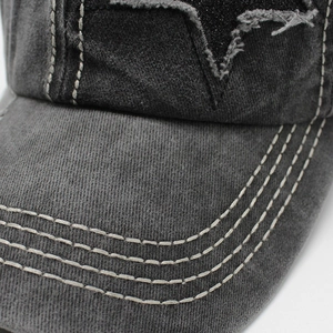 Détail d'une casquette en coton délavé gris avec patch étoile et bord surpiqué