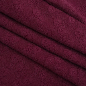 Vue macro d'un tissu de dentelle florale bordeaux aux motifs complexes et à la texture douce