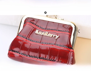 Close-up of glossy deep red crocodile pattern leather coin purse with gold metal clasp