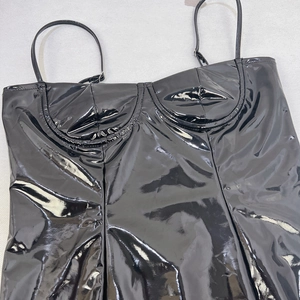 Détail d'une mini robe en cuir PU noir brillant avec de fines bretelles et texture PVC