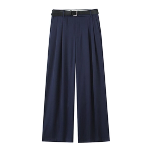 Détail du pantalon large bleu marine avec plis et ceinture en cuir noir assortie