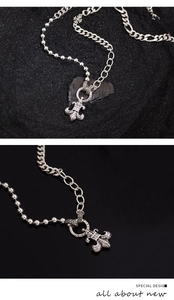 Macro shot of silver fleur-de-lis pendant with zircons and S925 hallmark on a curb chain