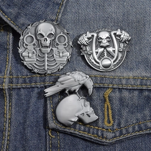 Detailed view of punk gothic skeleton brooches on denim, showing retro metal textures