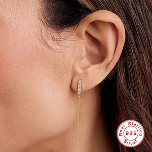 Model wearing 925 sterling silver gold drop earrings with cubic zirconia stones and chains