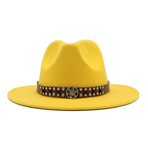 Detail of bright yellow wool fedora featuring a leather band with vintage metal studs