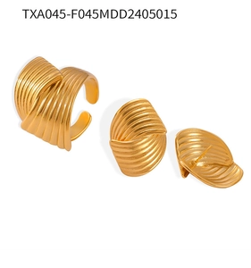 Macro shot of 18K gold plated jewelry set with textured wavy rings and earrings